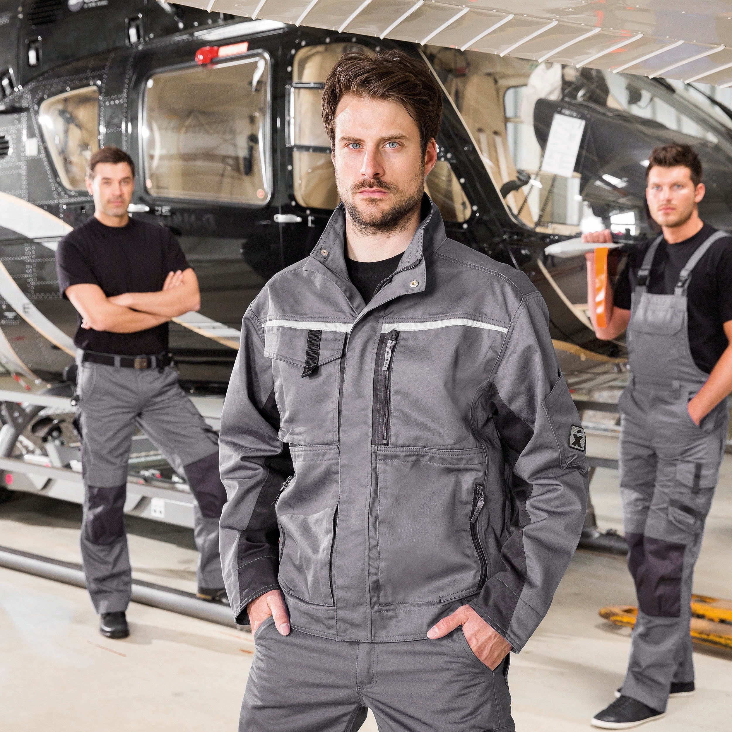 Graue CHAMP Arbeitsjacke – Sportliche Arbeitsjacke mit verdecktem Reißverschluss und vielen praktischen Taschen.