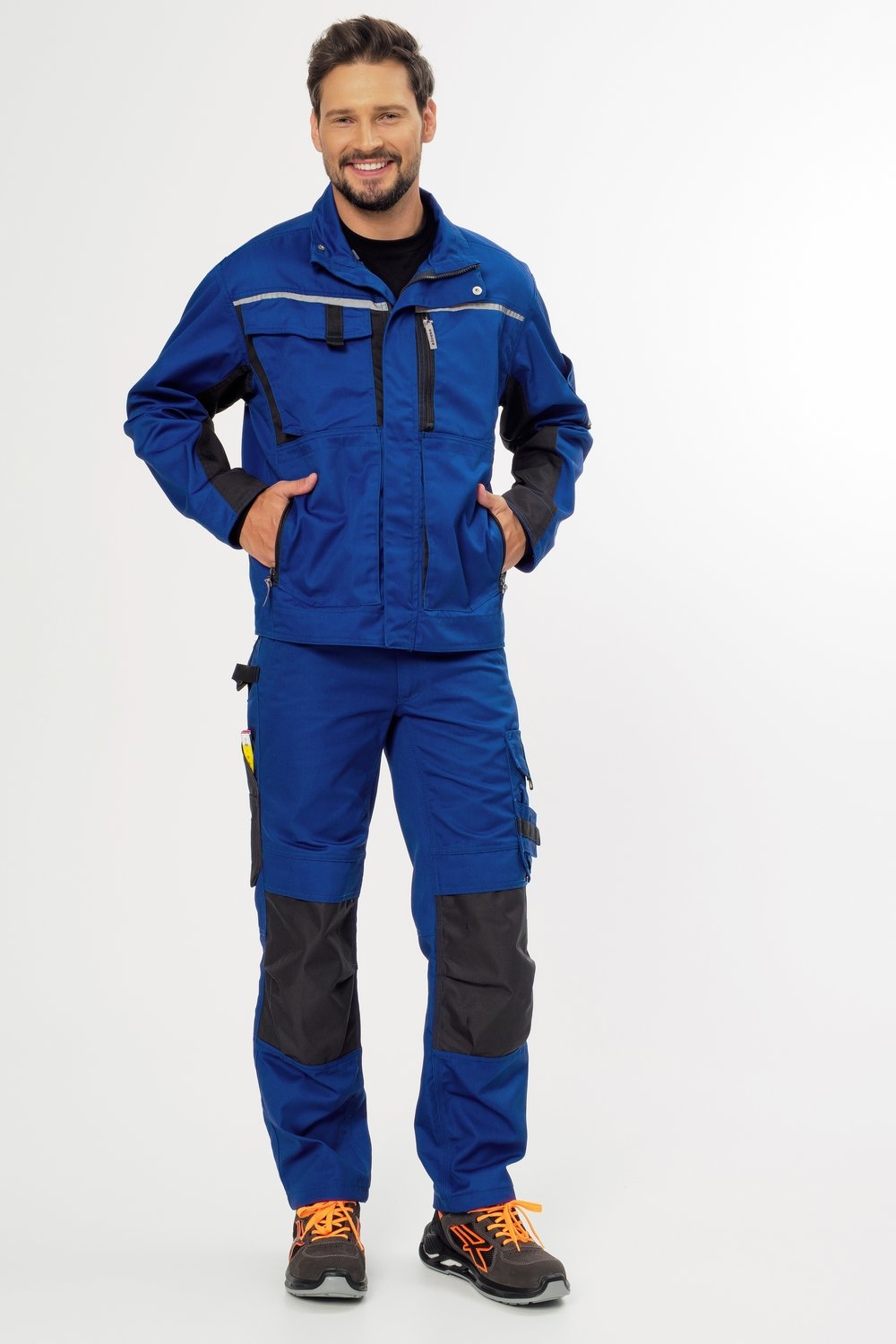 Blaue Arbeitsjacke und Hose mit grauen Knieverstärkungen – robuste Workwear für Handwerk, Bau und Industrie mit Sicherheitsschuhen.