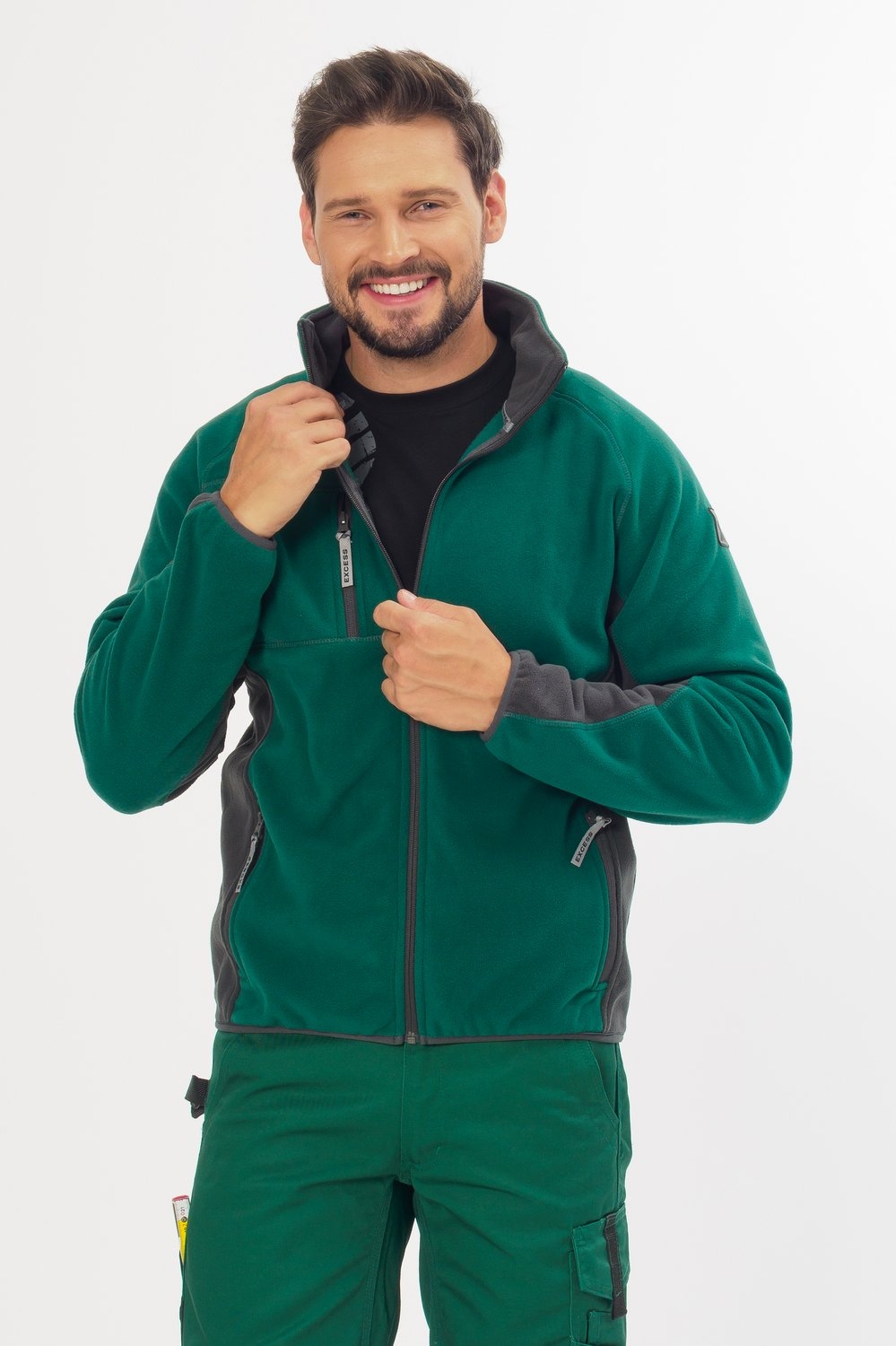 Excess Workwear Fleecejacke in Grün mit grauen Einsätzen, Reißverschluss, Brusttasche und sportlichem Schnitt.