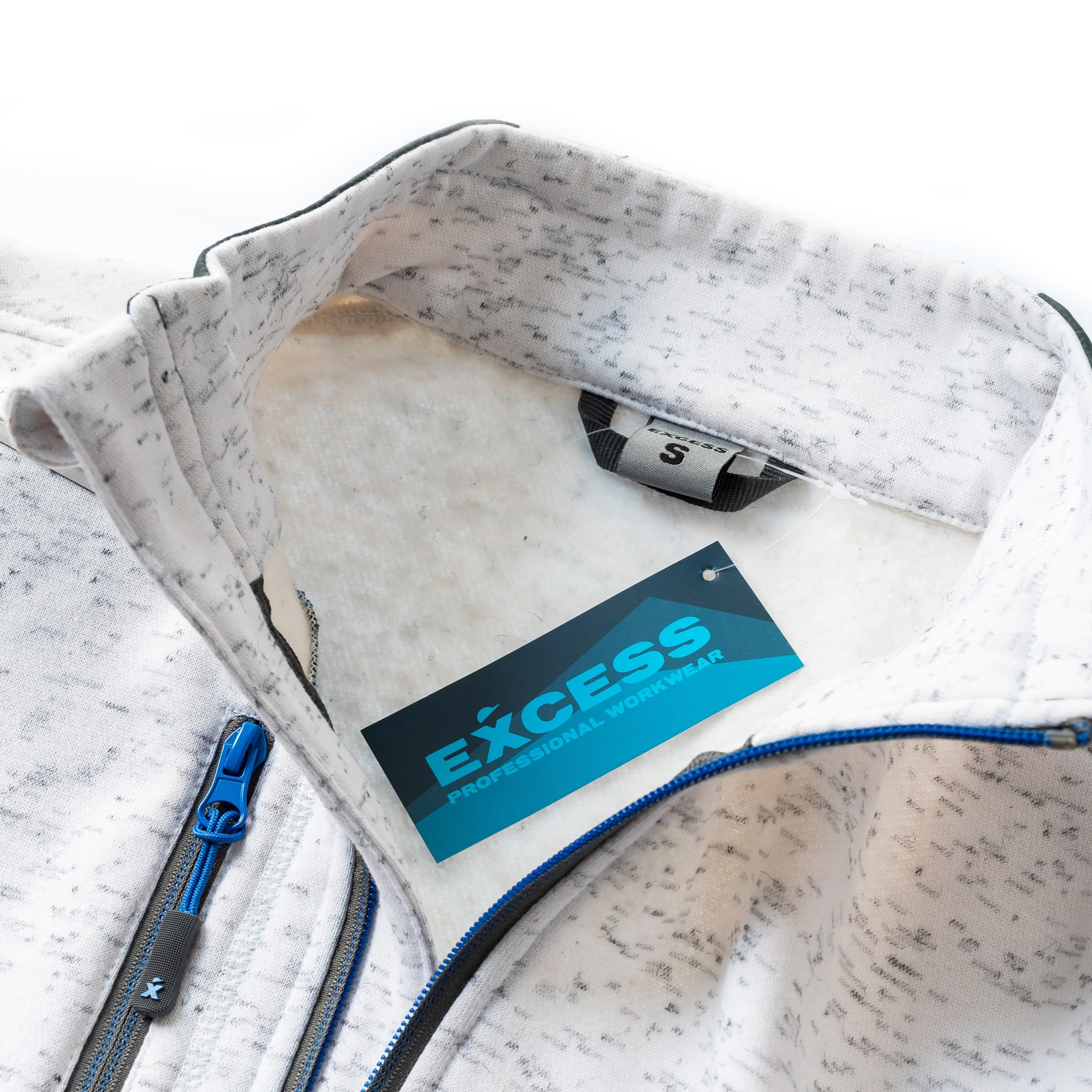 Nahaufnahme einer weiß-grau melierten Jacke von Excess Workwear mit blauem Markenetikett, Größenlabel und Zipper-Detail. Fokus auf den hochwertigen Reißverschluss und die feine Materialstruktur.